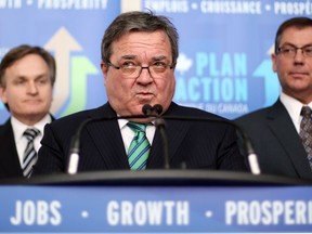 In this file photo, Finance Minister Jim Flaherty, centre, is flanked by Benoit Robidoux, Assistant Deputy Minister of Finance, left, and Kevin Sorenson Minister of State for Finance as he holds a news conference in Ottawa Monday, January 27, 2014. (THE CANADIAN PRESS/Fred Chartrand)