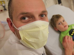 Dylan Lanspeary sits with his son Lucas Lanspeary at the Windsor Regional Hospital in Windsor on Monday, January 6, 2014. Visitors have been asked to wear masks due to a recent outbreak of influenza.                       (TYLER BROWNBRIDGE/The Windsor Star)