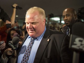 File photo of Toronto Mayor Rob Ford surrounded by the media as he leaves his office at Toronto City Hall in this November 15, 2013.  Toronto's larger-than-life mayor, Rob Ford, who was stripped of most of his powers in November after admitting he had smoked crack, launched his bid for re-election on January 2, 2014. "Just filed my paperwork for the 2014 election. Vote on October 27th," Ford said on Twitter, alongside a picture of himself, brother Councillor Doug Ford and a city official looking over documents. Ford has been mired in scandal since October, accused of unseemly behavior and sexual harassment during a series of drunken rampages in addition to his admitted crack use. He denies the most serious charges, and has always insisted he would seek a second term as mayor of Toronto, North America's fourth largest city and Canada's commercial and financial hub. (GEOFF ROBINS/AFP/Getty Images)