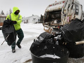 Sanitation worker Joel Morris picks up garbage bags on Frank Avenue on Thursday, Jan. 16, 2014, in Windsor, Ont. As of March 1, 2014, crews will no longer pick up garbage in bags. (DAN JANISSE/The Windsor Star)