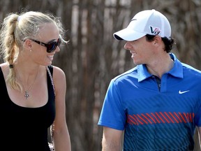 Golfer Rory McIIroy and tennis player Caroline Wozniacki announced their engagement Jan. 1, 2014, on Twitter. In this file photo, Wozniacki of Denmark and McIlroy of Northern Ireland are shown after the first round of the DP World Tour Championship, on the Earth Course at the Jumeirah Golf Estates on November 14, 2013 in Dubai, United Arab Emirates.  (Photo by Ross Kinnaird/Getty Images)