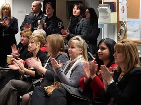 Barbara Iacono, right, and Mehnaz Fafat, both of Family Services Windsor-Essex, Kathy Macintyre, centre, City of Windsor social services and other community leaders applaud Windsor Fire Chief Bruce Montone after he announced the creation of a coalition to deal with hoarding issues in Windsor January 8, 2014. (NICK BRANCACCIO/The Windsor Star)