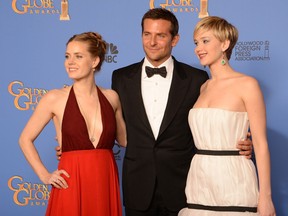 Actors Amy Adams, Bradley Cooper and Jennifer Lawrence, who won in Best Motion Picture - Musical or Comedy for "American Hustle", pose in the press room during the 71st Annual Golden Globe Awards in Beverly Hills, California, January 12, 2014. AFP PHOTO / Robyn BECKROBYN BECK/AFP/Getty Images