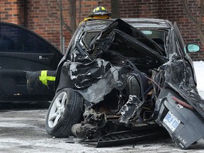 A woman waits for a firefighter to retrieve items from a car involved in a four-vehicle collision, Tues. Jan. 21, 2014, on University Ave. just west of McDougall. The accident occurred at approximately 1:00 p.m. Injuries were not life-threatening. (DAN JANISSE/The Windsor Star)