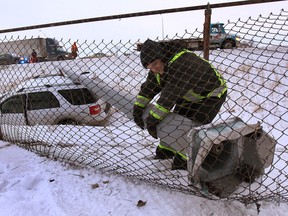 A tow truck operator attempts to move a light pole off an SUV that crashed into a ditch on the EC Row westbound lanes just east of Howard Ave, on Thurs. Jan. 30, 2014 at aproximately 5:30 p.m.   (DAN JANISSE/The Windsor Star)