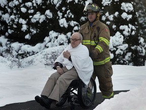 A senior from the Brouillette Manor in Tecumseh, Ont. is evacuated by a Tecumseh firefighter on Wed. Jan. 8, 2014. A burst water pipe caused ceiling damage and resulted in the evacuation.  (DAN JANISSE/The Windsor Star)
