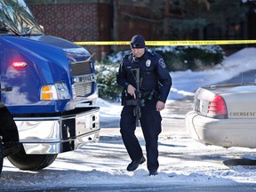 A police officer responds outside the Electrical Engineering building after shots were fired on Tuesday, Jan. 21, 2014, on the campus of Purdue University in West Lafayette, Ind.  Officials at Purdue University say one person has been killed in a shooting at the campus classroom building. Purdue Provost Tim Sands says he didn't immediately know the identity of the person killed or the person's connection to the university. Campus police chief John Cox says the suspect is in custody after surrendering outside the Electrical Engineering Building following the shooting.   (AP Photo/Journal & Courier, John Terhune)