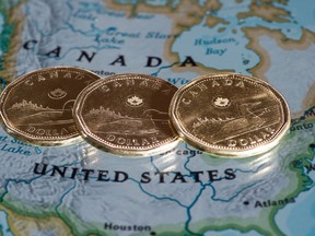 Canadian dollar coins, or Loonies, are displayed on a map of North America Thursday, January 9, 2014 in Montreal. (THE CANADIAN PRESS/Paul Chiasson)