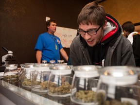 Tyler Williams of Blanchester, Ohio selects marijuana strains to purchase at the 3-D Denver Discrete Dispensary on January 1, 2014 in Denver, Colorado. Legalization of recreational marijuana sales in the state went into effect at 8am this morning. (Photo by Theo Stroomer/Getty Images)