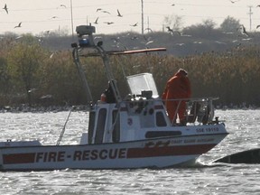 In this file photo, the LaSalle Fire Department search and rescue boat passes a canoe -- after  two men  fell into the cold waters of  the Detroit River when the canoe capsized.    LaSalle Fire department, the coast guard accompanied by a United States Coast Guard helicopter searched the river for a missing man.   (Jason Kryk/ Windsor Star)