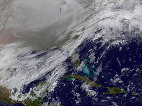 This image captured by NOAA's GOES-East satellite on Jan. 6, 2014, at 11:01 a.m. EST shows a frontal system that is draped from north to south along the U.S. East Coast. Behind the front lies the clearer skies bitter cold air associated with the polar vortex. Forecasters said some 187 million people in all could feel the effects of the "polar vortex" by the time it spread across the country on Tuesday, Jan. 7. 2013. (AP Photo/NASA)