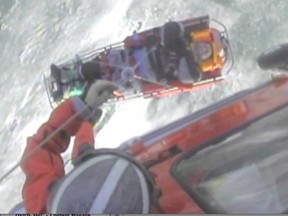 Crew members from U.S. Coast Guard Air Station Detroit hoist a Canadian man who was injured on Lake St. Clair when his all-terrain vehicle overturned, Jan. 14, 2014. The man was brought to shore and transferred to EMTs in Ontario. (Photo U.S. Coast Guard courtesy Air Station Detroit)