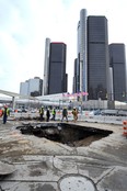 Work crews examine a 14-feet-deep sinkhole Monday, Jan. 20, 2014 that opened up in downtown Detroit over the weekend. Officials learned there was a water main break about 14 feet underground, which caused the surface to collapse, according to the Detroit News. (AP Photo/The Detroit News, Max Ortiz)