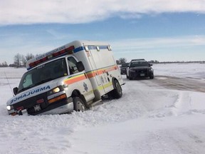 An ambulance skidded off the road and plowed into a pile of snow on Concession 12 in McGregor on Jan. 30, 2014. (TwitPic: Jason Kryk/The Windsor Star)