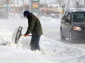 Tim Liu tries to keep up with blowing snow on Tecumseh Road West near Huron Church Road as area residents deal with heavy snowfall and low temperatures Monday January 6, 2014. (NICK BRANCACCIO/The Windsor Star)