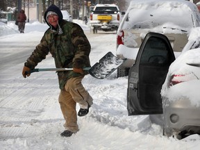 Good Samaritan Russell Meloche jumps over a snow bank while removing snow from around his neighbour's car on Mill Street Monday January 6, 2014. (NICK BRANCACCIO/The Windsor Star)