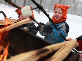 Jacob Juhasz, 3, left, and his brother, Zachery Juhasz, 4, roast marshmallows while tobogganing at Optimist Memorial Park in Windsor, Ont., Sunday, Jan. 5, 2014.  (DAX MELMER/The Windsor Star)