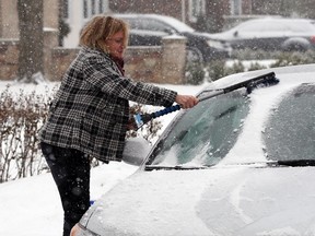 Her first day back from a trip to Florida, Urszula Kowalik wipes snow from her vehicle as another snowfall slams the Windsor and Essex County region Thursday, January 16, 2014, in this file photo. (NICK BRANCACCIO/The Windsor Star)