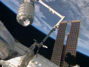 This NASA TV handout image shows the Orbital Sciences Corporation's unmanned Cygnus cargo ship, top left, being captured by the Canadarm after arriving at the International Space Station on January 12, 2014. The Cygnus cargo ship on Sunday arrived at the International Space Station on the company's first regular supply mission to the research outpost. The capsule officially berthed with the space station at 13:05 GMT nearly two hours after a robotic arm reached out and grabbed the incoming cargo carrier, according to the U.S. space agency NASA's television network. US astronaut Mike Hopkins and his Japanese colleague Koichi Wakata operated the space lab's 57-foot Canadian-made mechanical arm, known as the Canadarm, which connected with Cygnus at 11:08 GMT. (AFP PHOTO/NASA TV)