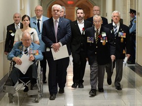 Veterans and PSAC members make their way to hold a news conference on Parliament Hill in Ottawa on Tuesday, January 28, 2014. The groups is asking ask the government to reconsider its decision to close Veterans Affairs district offices in nine communities. (THE CANADIAN PRESS/Sean Kilpatrick)