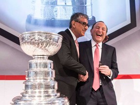 In this file photo, Rogers' CEO Nadir Mohamed, left, shares a joke with NHL Commissioner Gary Betman following a news conference in Toronto on Tuesday 26, 2013 as they announced a long-term broadcast and multimedia agreement, which provides Rogers with all national rights.  The Rogers Communications deal to lock up the National Hockey League television and multimedia broadcast rights has been voted the 2013 Canadian Press Business News Story of the Year. (THE CANADIAN PRESS/Chris Young)