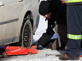 Windsor police collect evidence from the rear wheel of a Chevrolet Malibu after shots were fired near 827 Randolph Ave. early Tuesday, Jan. 21, 2014. (NICK BRANCACCIO/The Windsor Star)