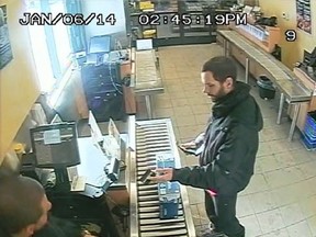 The Essex County Ontario Provincial Police is currently investigating a break-in that occurred in December on Wigle Street in Leamington.
An unknown male is shown using the stolen card to make a purchase at the Beer Store on Goyeau Street in Windsor on January 6, 2014. (Courtesy of Essex OPP)