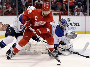 Detroit's Henrik Zetterberg, centre, tries to score on St. Louis goalie Brian Elliott at Joe Louis Arena. (AP Photo/Paul Sancya)