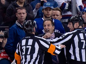 Canucks head coach John Tortorella, centre, screams at the Calgary Flames bench during first period Saturday at Rogers Arena. (THE CANADIAN PRESS/Jonathan)