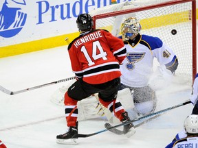 Former Spitfire Adam Henrique, left, scores a goal against the Blues in Newark, N.J. (AP Photo/Bill Kostroun)