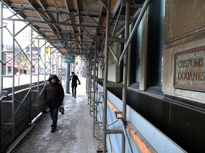 Pedestrians navigate through scaffolding erected around the Paul Martin Building Friday January 24, 2014. (NICK BRANCACCIO/The Windsor Star)