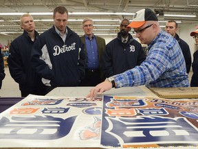 Dan Izzo, right, explains the Fathead making process to Tigers pitcher Max Scherzer, left, and other members of the organization during a visit in Battle Creek, Mich. (AP Photo/Battle Creek Enquirer, John Grap)