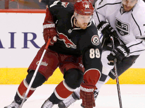 Phoenix forward Mikkel Boedker, left, is checked by L.A.'s Dwight King in Glendale, Ariz. (AP Photo/Ross D. Franklin)