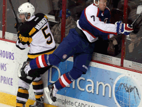 Spits forward Cameron Hughes, right, misses a check on Kingston's Mikko Vainonen at the WFCU Centre. (TYLER BROWNBRIDGE/The Windsor Star)