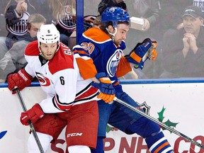 Ex-Spitfire Tim Gleason, left, checks Edmonton's Luke Gazdic. (THE CANADIAN PRESS/Jason Franson)