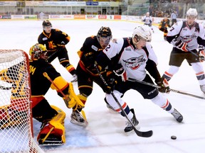 Spits defenceman Patrick Sanvido, second from right, is checked by Belleville's Alex Yuill in front of goalie Charlie Graham. Windsor’s Steven Janes, right, looks for a rebound. (Aaron Bell/OHL IMAGES)