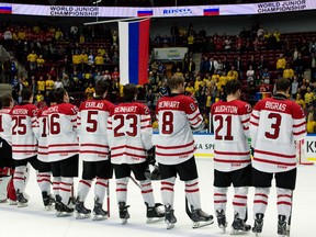 Tecumseh's Kerby Rychel, fourth from left, and Belle River's Aaron Ekblad, fifth from left, stand on the blueline asd the Russian flag is raised after Canada lost 2-1 to Russia in the bronze medal game at the World Junior Hockey Championships in Malmo, Sweden. (THE CANADIAN PRESS/ Frank Gunn)