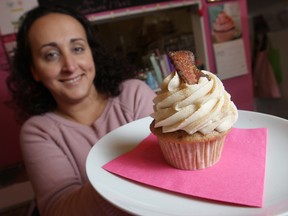 Sonia Klue holds a Canadian maple bacon cupcake at her store, Klueless Cupcakes. The cupcake is made with maple syrup butter cream with bacon and syrup baked into the cupcake with a slice of bacon and edible glitter on top. (DAX MELMER / The Windsor Star)