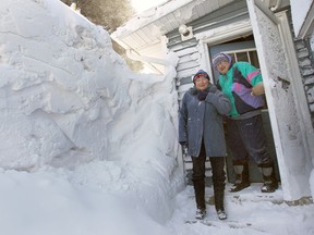 Janet and Mike Wilton are dwarfed by a snow drift at the entrance of their Lakewood Drive home in Amherstburg on Jan. 29, 2014. (Dan Janisse / The Windsor Star)