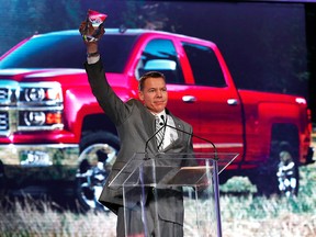 General Motors executive chief engineer Jeffrey Luke holds up the North American Truck of the Year award after the Chevrolet Silverado won at the North American International Auto Show in Detroit, Monday, Jan. 13, 2014. (AP Photo/Paul Sancya)