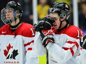 Canada's Derrick Pouliot, right, reacts with teammates after losing the World Junior Hockey Championships bronze medal game against Russia at Malmo Arena in Malmo, Sweden, Sunday, Jan. 5, 2014. (AP Photo/Ludvig Thunman, TT News Agency)