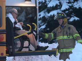 A Tecumseh firefighter loads an elderly resident of Brouillette Manor into a school bus on Jan. 8, 2014. (Dan Janisse / The Windsor Star)