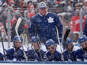 Maple Leafs head coach Randy Carlyle, cetnre, talks to his team during the Winter Classic outdoor NHL hockey game against the Detroit Red Wings at Michigan Stadium in Ann Arbor Wednesday, Jan. 1, 2014. (AP Photo/Paul Sancya)