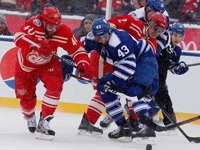 Detroit's Henrik Zetterberg, left, and Brendan Smith, baxk right, fight for the puck with Toronto's Nazem Kadri during the NHL Winter Classic at Michigan Stadium on January 1, 2014 in Ann Arbor. (Gregory Shamus/Getty Images)