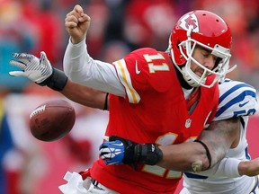 Kansas City QB Alex Smith, left, fumbles while being tackled by Indianapolis linebacker Jerrell Freeman in Kansas City, Mo., Sunday, Dec. 22, 2013. (AP Photo/Ed Zurga)