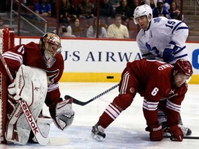 Phoenix goalie Mike Smith, left, makes a save in front of Toronto's Joffrey Lupul, right, Monday, Jan. 20, 2014, in Glendale, Ariz. (AP Photo/Rick Scuteri)