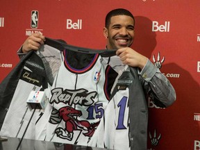 Hip Hop Star and MLSE ambassador Drake shows off the lining of his suit during a news conference before the Toronto Raptors' game against Brooklyn Nets in Toronto on Saturday January 11 , 2014. (THE CANADIAN PRESS/Chris Young)