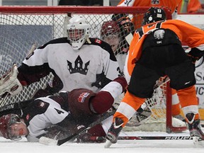 Dresden's John Montgomery, left, is hit by a shot from Essex's Matthew Hebert in front of goaltender Brent Paxton at the Essex Centre Sports Complex in Essex on Tuesday, January 14, 2013. (TYLER BROWNBRIDGE/The Windsor Star)