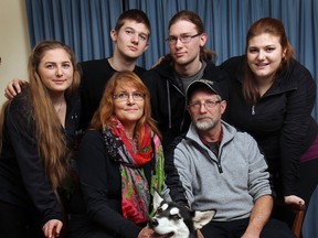 Mike and Patricia Schaafsma pose with their children, Hannah, 17, (L), Noah, 14, Zachary, 21, and Anita, 19, in Essex, Ont. on Mon. Jan. 13, 2014. The family's dream home in Kingsville burnt down over the weekend. The family dog Abby, a Christmas present, also survived the devastating fire.  (DAN JANISSE/The Windsor Star)