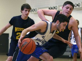 Michel-Gratton's Ali Nadi, centre, drives past Western's C.J. Sevigny during WECSSAA senior boys basketball at Michel-Gratton Secondary School, Friday, Jan. 17, 2014.   (DAX MELMER/The Windsor Star)